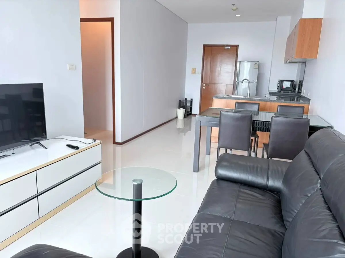 Modern living room with sleek furniture and open kitchen layout in a stylish apartment.