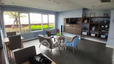 Spacious living room with modern furniture and large windows offering natural light.