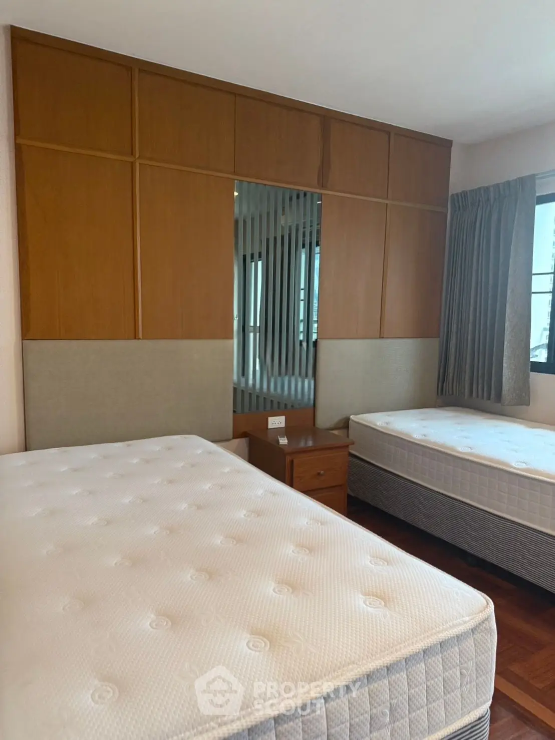 Spacious bedroom with twin beds and modern wooden paneling