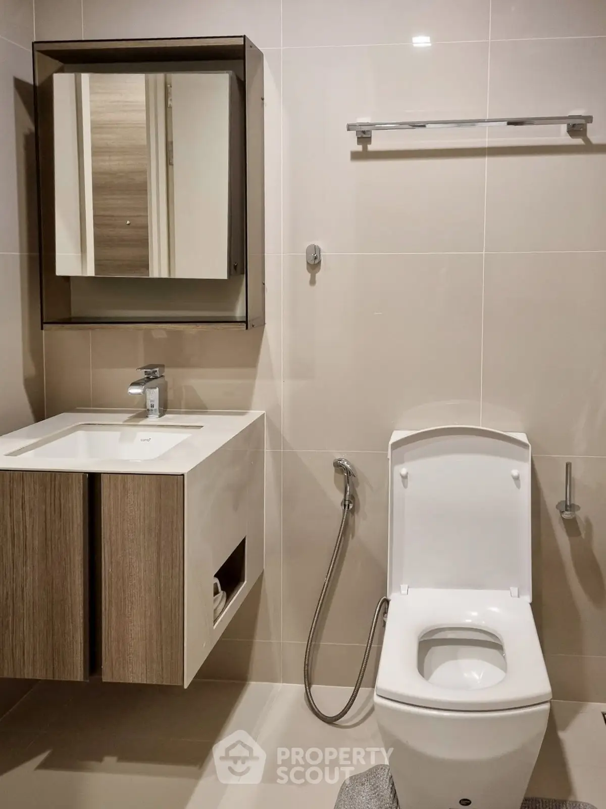 Modern bathroom with sleek fixtures and neutral tones, featuring a stylish vanity and toilet.