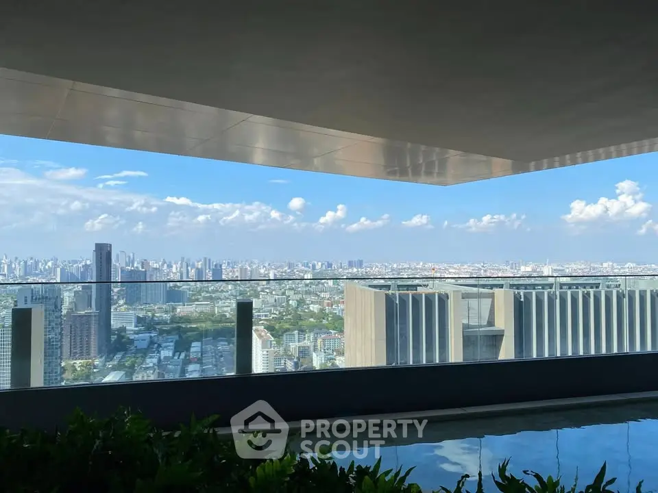 Stunning cityscape view from a modern high-rise balcony with glass railing and lush greenery.