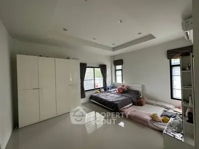 Spacious bedroom with modern design and large windows for natural light.