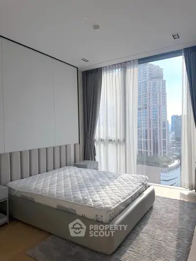 Luxurious bedroom with floor-to-ceiling windows offering stunning city views in a modern high-rise apartment.