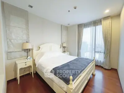 Spacious bedroom with elegant decor and large window offering city views