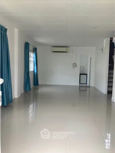 Spacious empty room with glossy tiled floor and blue curtains, ideal for customization.