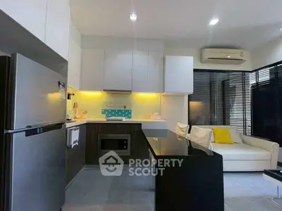 Modern kitchen and living room with sleek design and bright lighting