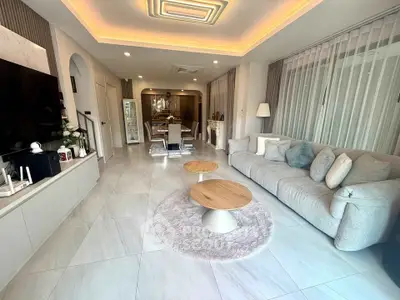 Spacious modern living room with elegant decor and open layout, featuring cozy seating and stylish lighting.