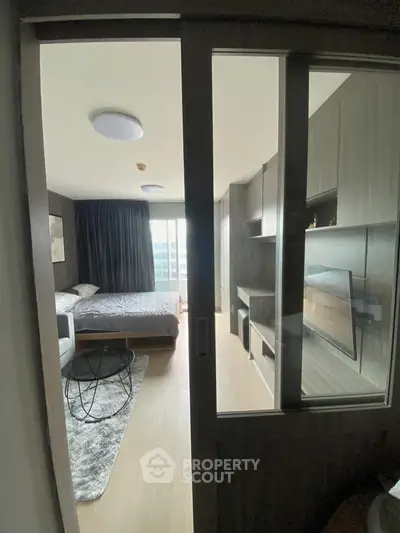 Modern bedroom with sliding glass doors, stylish decor, and natural light.