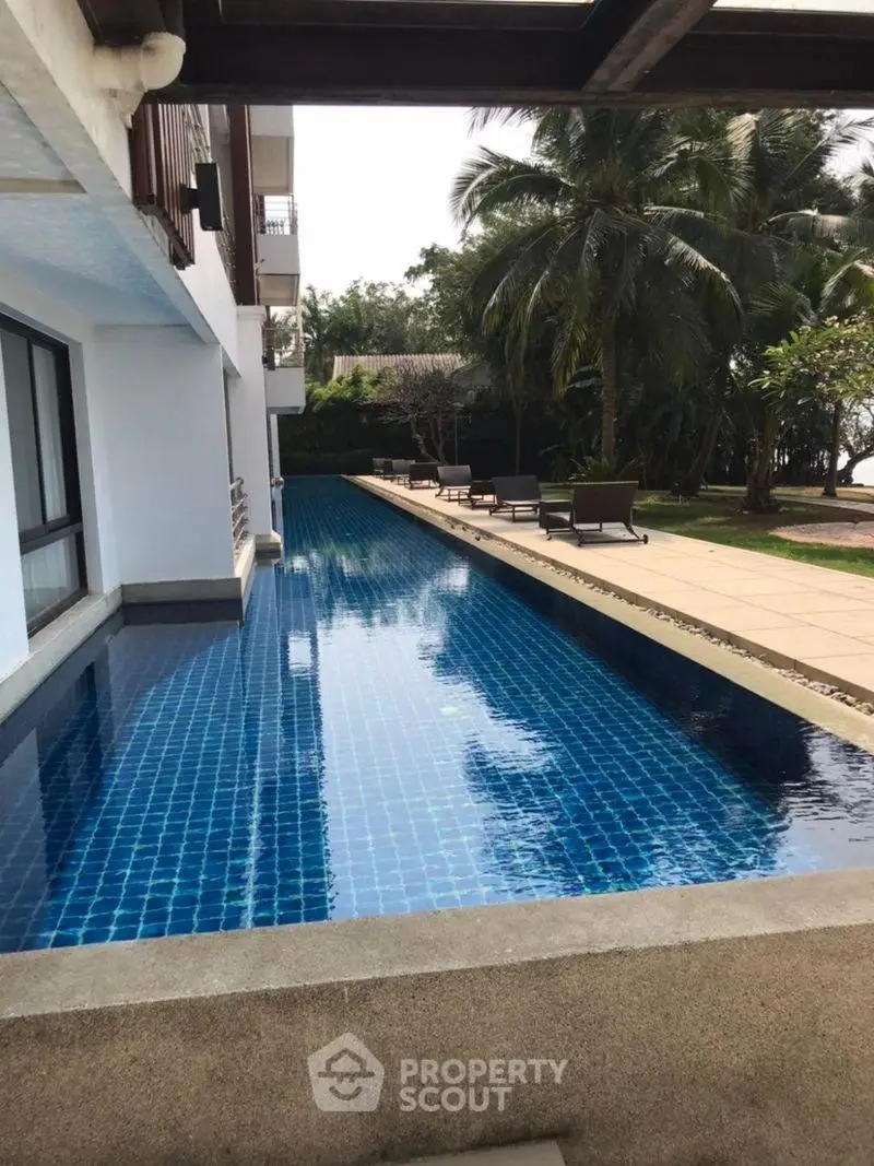 Luxurious property with stunning poolside view and lush greenery, perfect for relaxation and leisure.