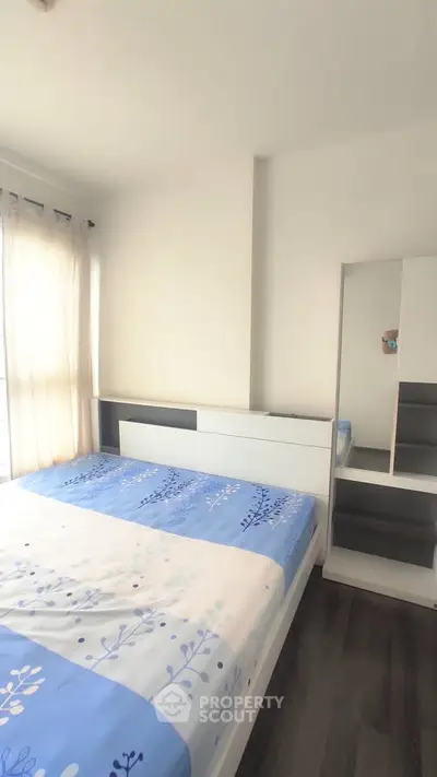 Bright and cozy bedroom with modern furnishings and large window for natural light.