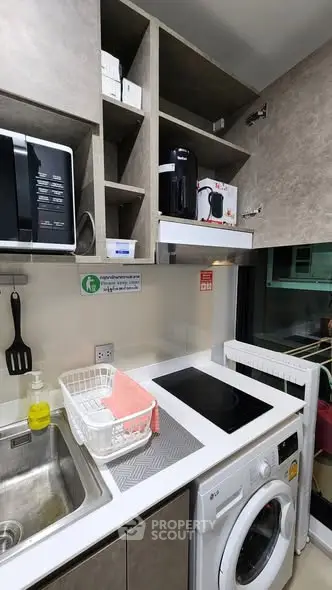 Modern kitchen with washing machine, microwave, and sleek cabinetry