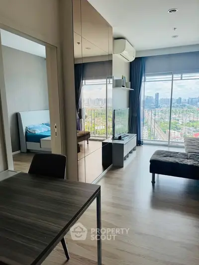 Modern living room with city view, featuring sleek furniture and large windows.
