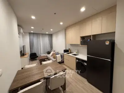 Modern open-plan living room and kitchen with stylish furniture and appliances.