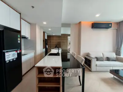 Modern open-layout kitchen and living room with sleek design and contemporary furniture.