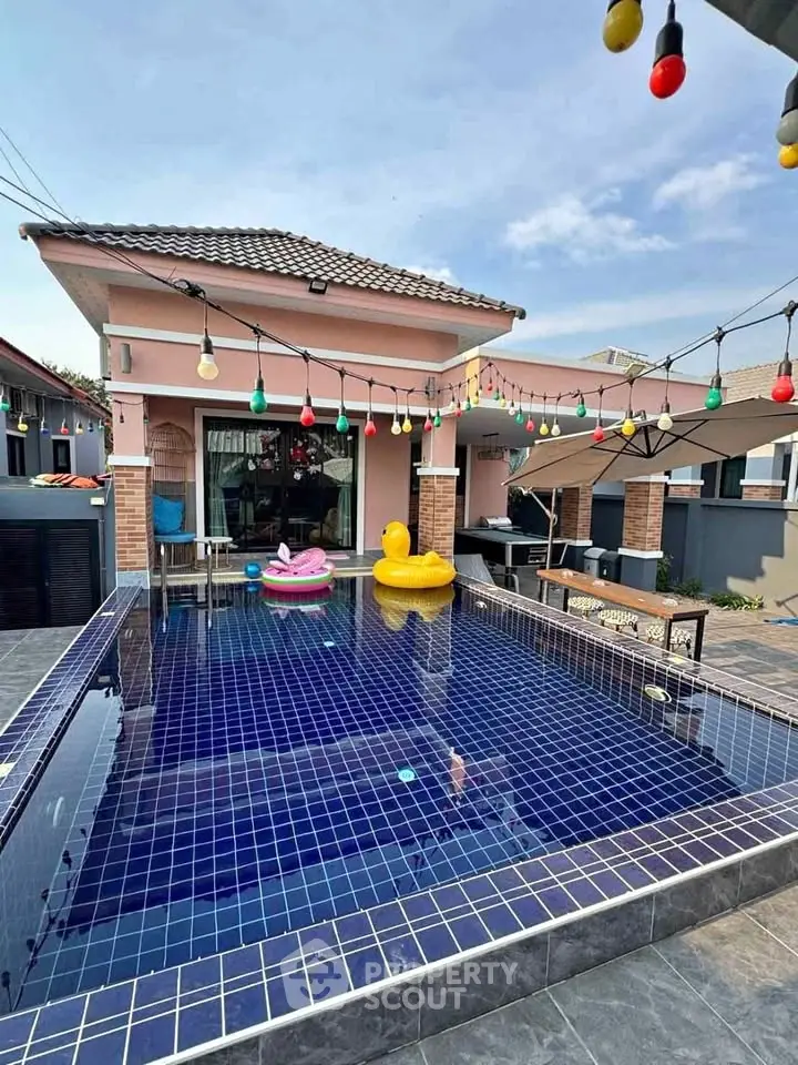 Charming home with a vibrant pool and festive lighting, perfect for relaxation and entertainment.