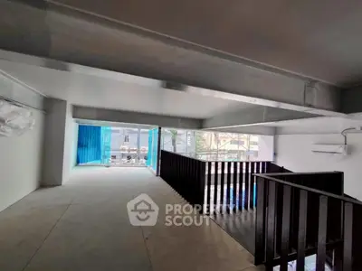 Spacious modern interior with large windows and sleek design, ideal for urban living or office space.