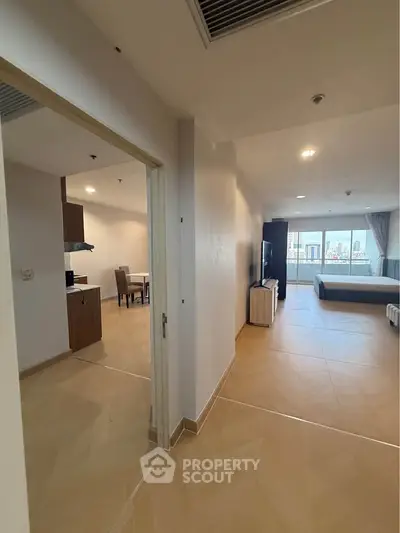 Spacious open-plan apartment with modern kitchen and large windows offering city views.