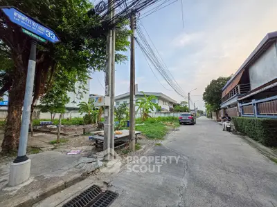 Charming suburban street view with lush greenery and residential homes, perfect for peaceful living.