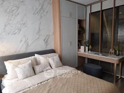 Luxurious bedroom with elegant marble wall and cozy bedding in modern apartment
