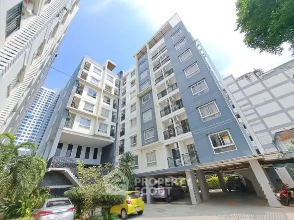 Modern apartment building with parking area and lush greenery