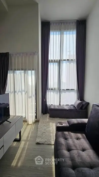 Spacious modern living room with high ceilings and large windows for natural light.