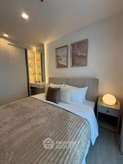 Cozy bedroom with modern decor and soft lighting, featuring a comfortable bed and stylish artwork.