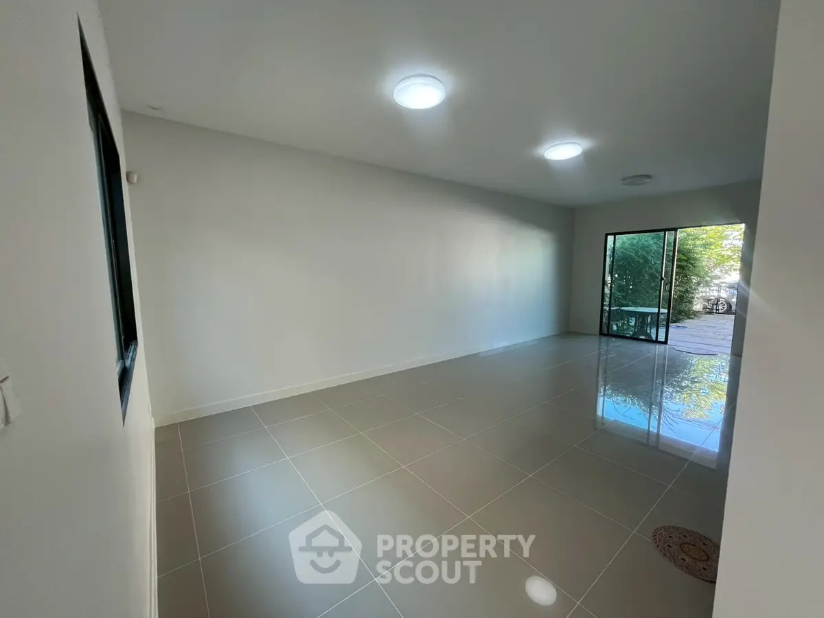 Spacious empty living room with large windows and garden view