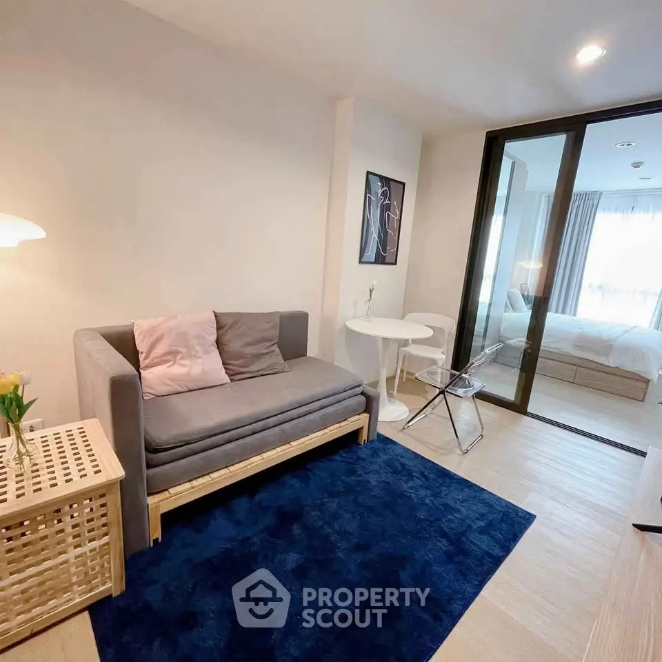 Modern living room with cozy sofa and stylish decor adjacent to a bright bedroom.