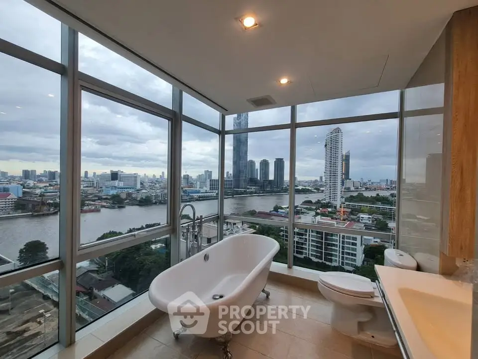 Luxurious bathroom with stunning city skyline view from floor-to-ceiling windows.