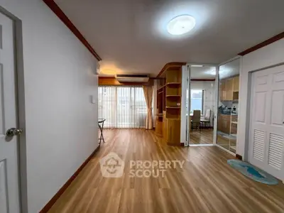 Spacious open-plan living room with wooden flooring and natural light
