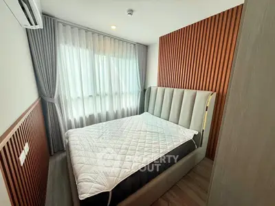 Modern bedroom with stylish wood paneling and large window for natural light