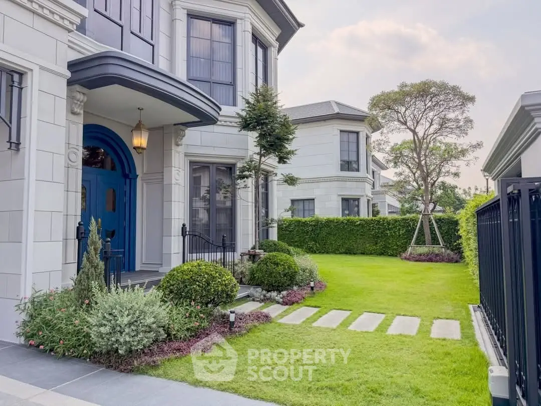 Elegant suburban home with manicured garden and charming blue door
