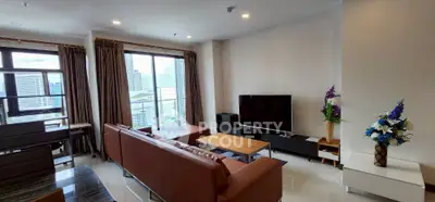 Spacious living room with modern furniture and city view balcony.