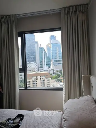 Stunning city view from a modern bedroom window, showcasing urban skyline.