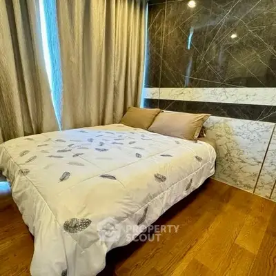 Luxurious bedroom with elegant marble accent wall and cozy bedding