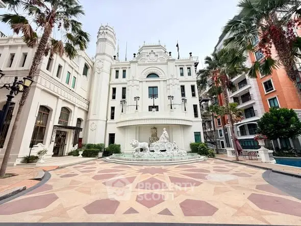 Stunning architectural building with elegant facade and courtyard, surrounded by palm trees and vibrant urban setting.