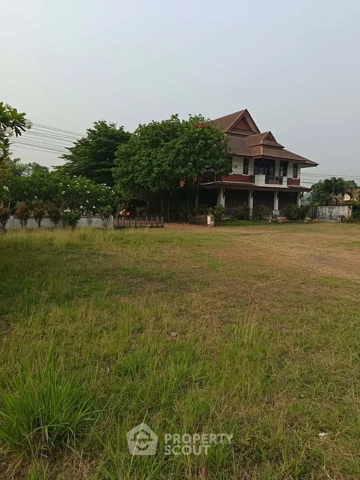 Charming two-story house with lush garden and spacious lawn, perfect for family living in serene neighborhood.