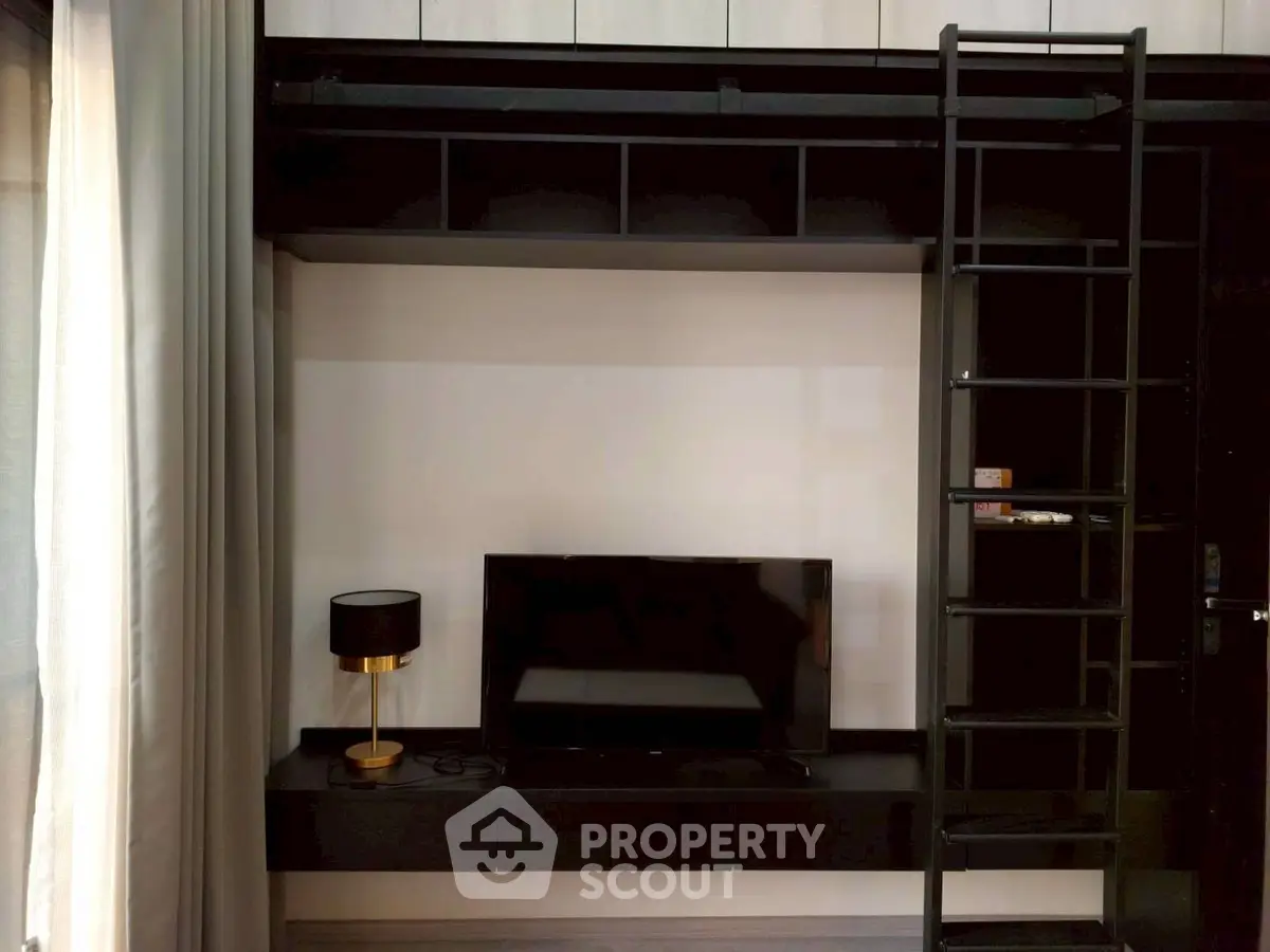 Modern living room with loft ladder and sleek black furniture, perfect for urban living.