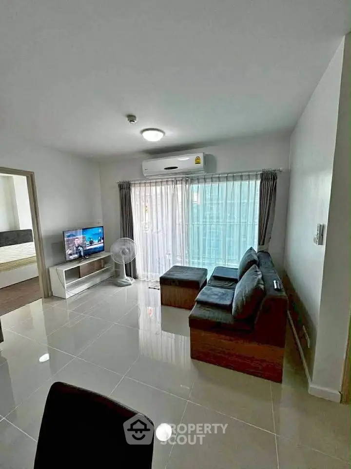 Modern living room with sleek furniture and large window in a stylish apartment.
