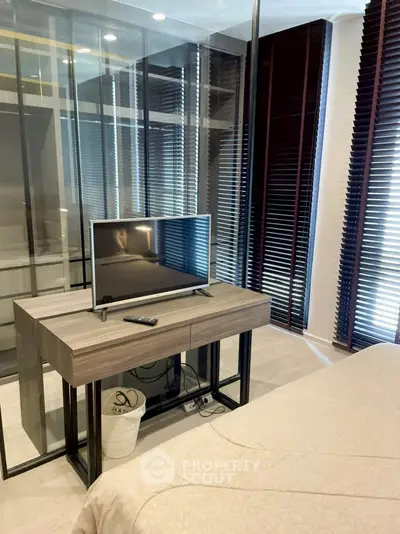 Modern bedroom with sleek glass partition and stylish TV setup