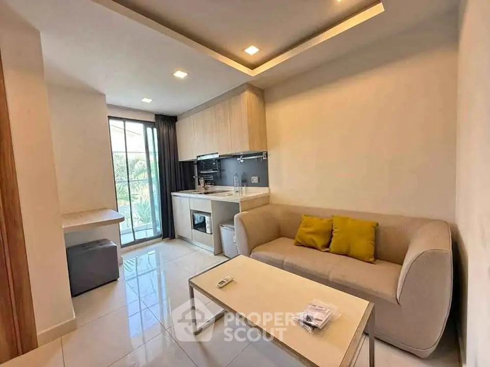 Modern living room with compact kitchen and balcony access