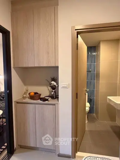 Modern apartment interior with compact bathroom and stylish storage cabinet.