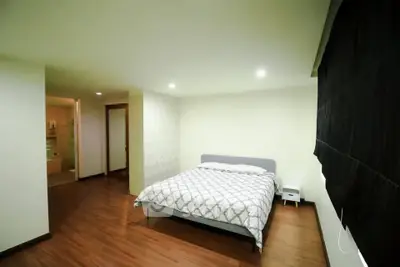 Spacious bedroom with modern decor and hardwood flooring