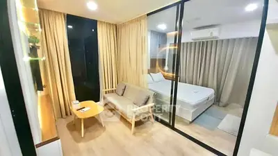 Modern studio apartment with glass partition, cozy living area, and elegant bedroom.