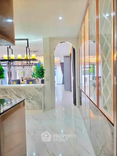Luxurious modern kitchen with marble countertops and elegant lighting in a spacious open layout.