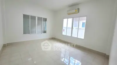 Spacious empty room with large windows and air conditioning unit