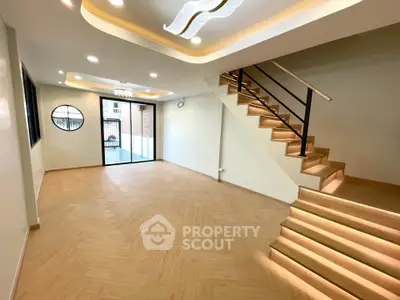 Spacious modern living room with elegant staircase and ample natural light