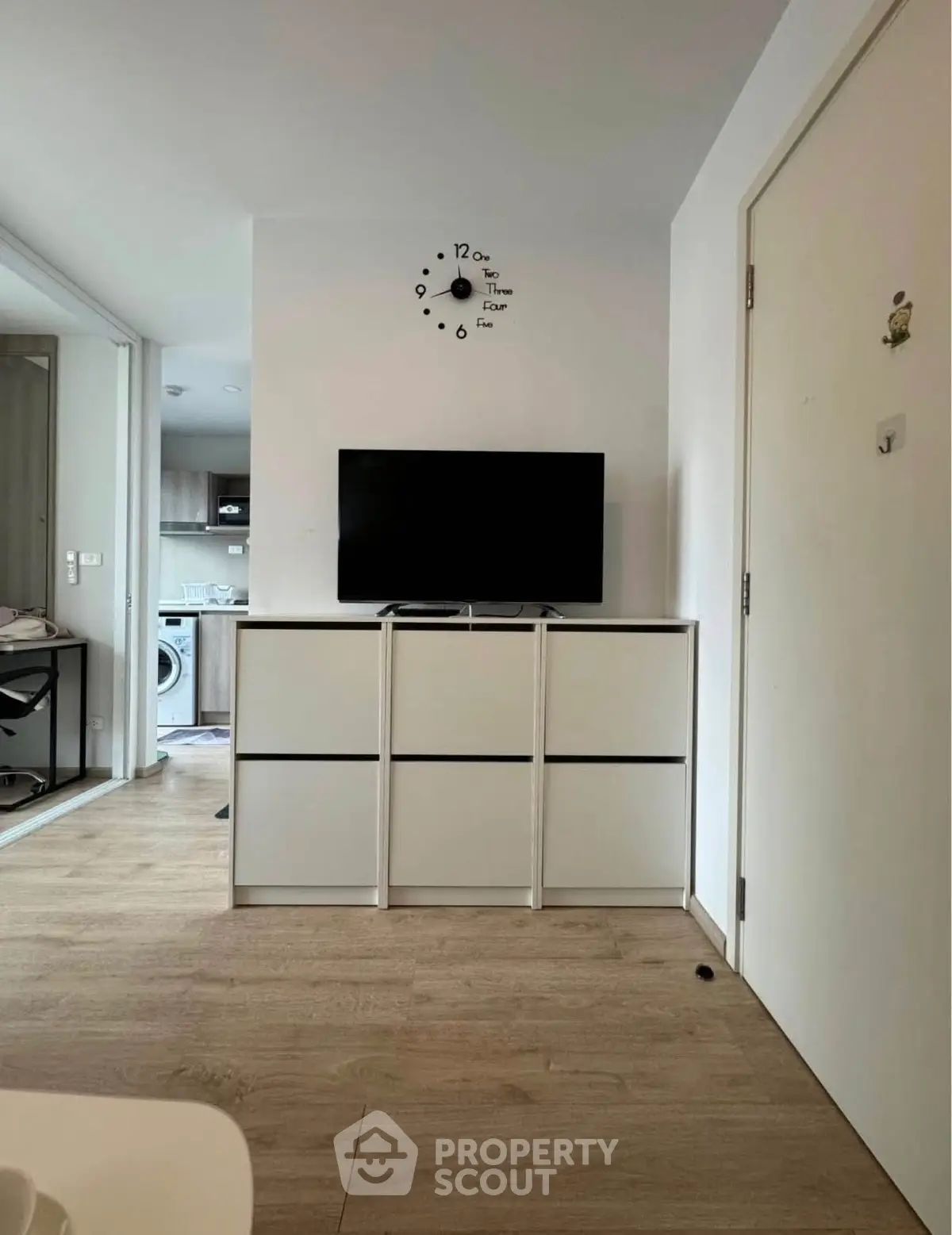 Modern living room with sleek TV setup and open kitchen view