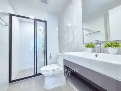 Modern bathroom with sleek design, glass shower, and elegant fixtures.