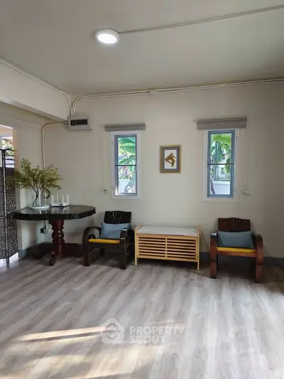 Charming living room with elegant wooden furniture and natural light, perfect for relaxation.